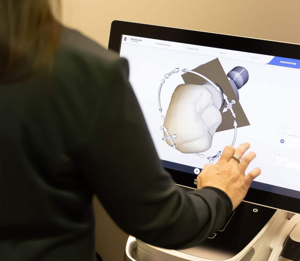 an assistant using a touchscreen to explore a digital model of a tooth