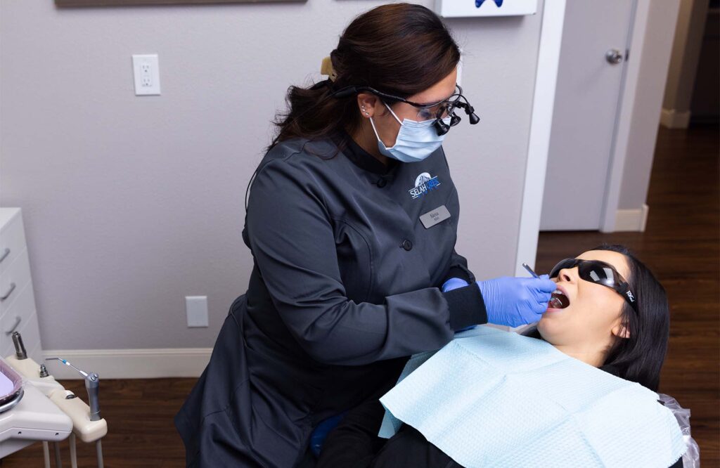 a hygienist inspecting a patient's teeth