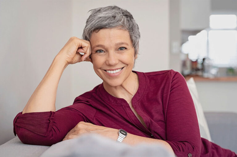 an older woman smiling on a couch